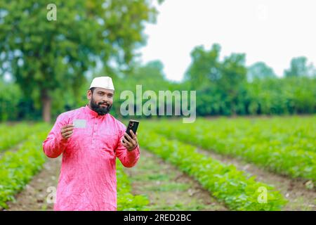 Contadino indiano con carta bancomat in mano, contadino indiano felice, contadino povero, lavoratore Foto Stock