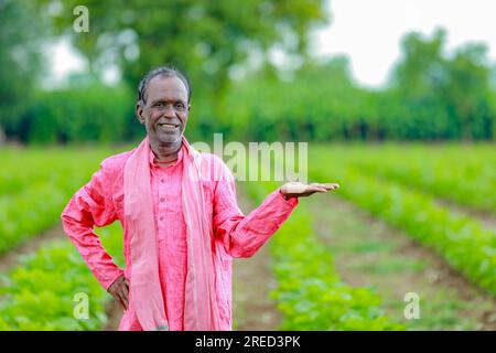 Indiano felice contadino che mostra mani vuote, felice vecchio povero contadino Foto Stock