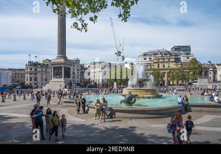 Persone che si godono una soleggiata giornata estiva a Trafalgar Square, Londra, Inghilterra, Regno Unito Foto Stock
