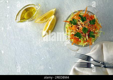 Insalata estiva leggera di cavolo cavolo con carote e prezzemolo, cosparsa di semi di sesamo e condita con olio d'oliva e succo di limone Foto Stock