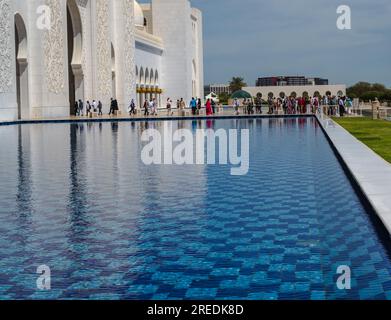 Abu Dhabi, Emirati Arabi Uniti - 17 aprile 2023. Una foto in formato orizzontale di turisti in attesa di entrare in piscina nella grande Moschea di Abu Dhabiwith. Foto Stock