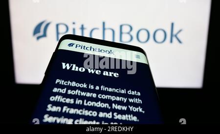 Telefono cellulare con sito Web della società statunitense di analisi PitchBook Data Inc. Sullo schermo davanti al logo aziendale. Mettere a fuoco in alto a sinistra sul display del telefono. Foto Stock