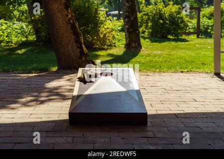 Tavola e sacchetti di fagioli per giocare a Cornhole nel cortile della casa in estate Foto Stock