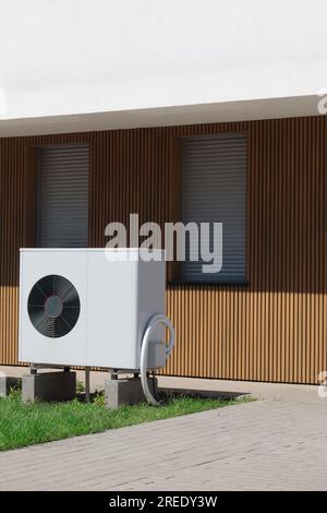 Immagine verticale di una pompa di calore con sorgente d'aria, una soluzione di riscaldamento sostenibile, installata in una casa di piscine residenziale. Foto Stock