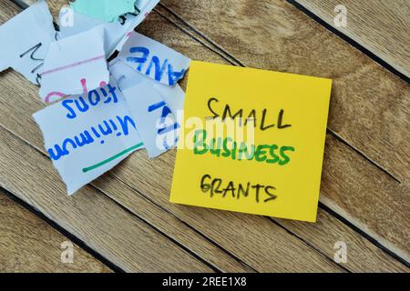 Concetto di piccole imprese borse scrivere su note appiccicose isolato su tavola di legno. Foto Stock