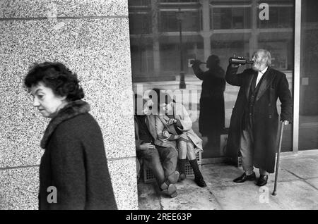 Senzatetto 1970s London. Un vecchio wino un vagabondo si gusta un drink da una bottiglia e il suo amico chiacchiera con una donna senzatetto. Un passante evita il gruppo. Victoria, Londra 1976 Regno Unito HOMER SYKES. Foto Stock