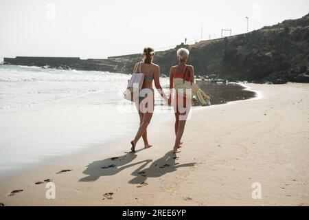 Lgtbi un paio di giovani donne che camminano sulla spiaggia tenendosi per mano. Concetto: Stile di vita, orgoglio, libertà Foto Stock