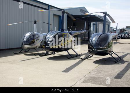 Diversi elicotteri Robinson sulla rampa dell'aeroporto di Brighton City. L-R R22, R66, R44 Foto Stock