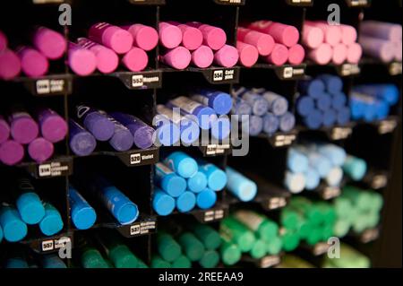 Messa a fuoco selettiva su matite e pastelli dai colori vivaci, esposti in vendita su uno scaffale del dipartimento d'arte di una scuola Foto Stock