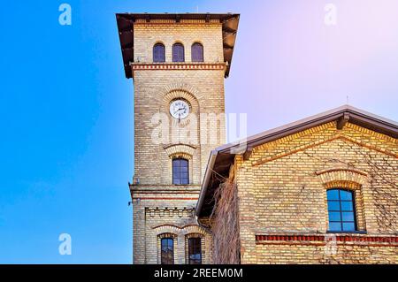 HDR shot di un mattone giallo edificio con torre dell'orologio Foto Stock