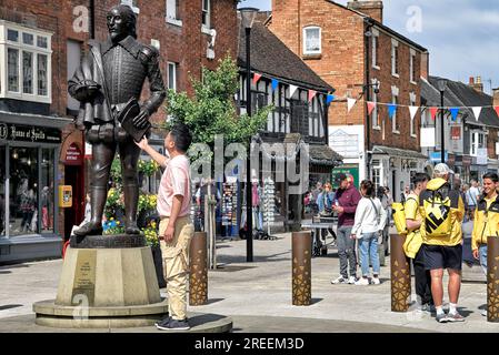 Statua di William Shakespeare in Henley Street Stratford Upon Avon, Inghilterra, Regno Unito con un uomo asiatico che sembra rendere omaggio. Centro città di Stratford Foto Stock