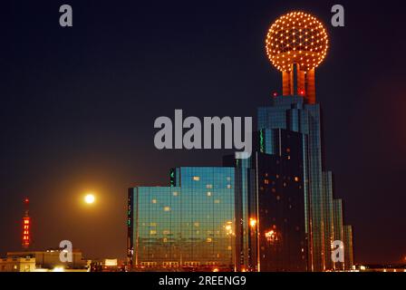 La luna piena sorge dietro il Reunion Center e lo skyline di Dallas, Texas Foto Stock