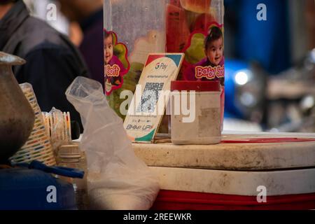 Un codice a barre UPI (Unified Payment Interface), o codice QR, viene tenuto a un banco affinché i clienti possano effettuare pagamenti digitali a Guwahati, India, venerdì 14 aprile Foto Stock