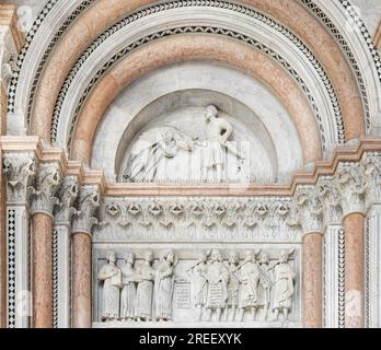 Il portale destro della facciata principale con la decapitazione del santo (Regulus) da parte del re gotico Totila nel timpano, architrave o architrave con Foto Stock