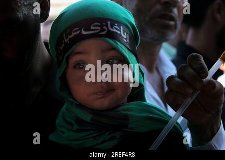 26 luglio 2023, Srinagar, Jammu e Kashmir, India: SRINAGAR, JAMMU E KASHMIR, INDIA - 2023/07/26: Una ragazza musulmana del Kashmir guarda verso la processione il settimo giorno di Muharram, nella periferia di Srinagar. (Immagine di credito: © Mubashir Hassan/Pacific Press via ZUMA Press Wire) SOLO USO EDITORIALE! Non per USO commerciale! Foto Stock