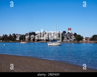 Una scena pittoresca si svolge a Winthrop, Suffolk County, Massachusetts, Stati Uniti, appena fuori Boston, dove una barca a vela adorna graziosamente la baia, con il Foto Stock