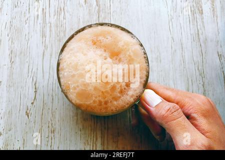 Il tè con latte o popolarmente noto come Teh Tarik in Malesia, vista dall'alto di Singapore, era piatto dall'alto con la mano dell'uomo, spazio vuoto per le copie per il testo Foto Stock