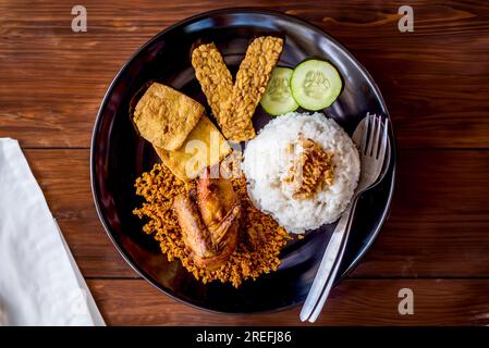 Nasi Uduk Betawi, o Nasi Lemak, piatto di riso al vapore aromatizzato al cocco di Betawi, Giacarta. Condito con diversi piatti, tofu tahu, soia, tempe, tempe Foto Stock