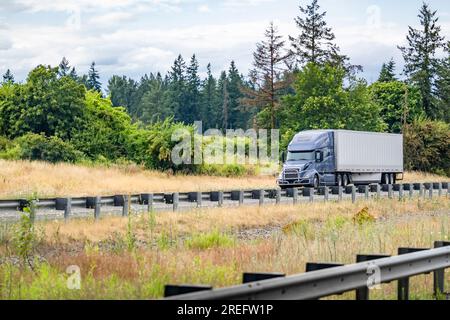 Trattore semirimorchio per trasporto lungo con carro di perforazione grande grigio di grado industriale con cabina alta per il riposo del conducente del veicolo che trasporta carichi commerciali in semirimorchi per furgoni asciutti Foto Stock