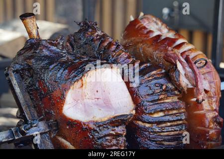 Cosce di maiale arrosto affumicate grigliate nel mercato del cibo di strada a Praga, Repubblica Ceca. Un grosso pezzo di carne. Foto Stock