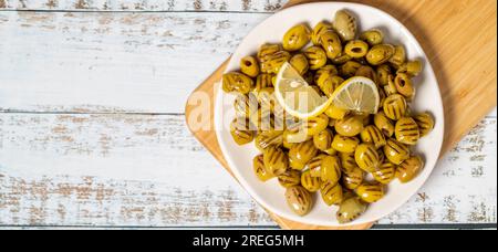 Olive grigliate. Olive verdi speciali su fondo di legno. Sapori mediterranei. Vista dall'alto. Copia spazio. Spazio vuoto per il testo Foto Stock
