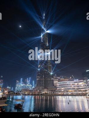 Spettacolo laser di notte al Burj Khalifa sotto la luce della luna con i turisti Foto Stock