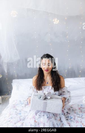 La ragazza tiene un regalo in mano sullo sfondo delle lanterne Foto Stock