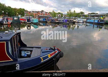 Canal boat in primo piano a Northwich Quay Marina con barche a remi ormeggiate e riflessioni sulle acque calme, Northwich, Cheshire, Inghilterra, Regno Unito CW9 Foto Stock