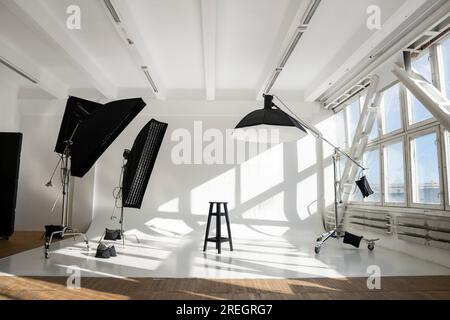 Grande e grande cyclorama bianco in moderno studio fotografico professionale con attrezzature professionali, leggietti, supporti e scatole morbide. Foto Stock