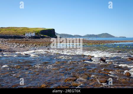 Cottage solitario alla foce del fiume Currane sul lungomare di Waterville, Spunkane, Ballinskelligs Bay, County Kerry, Irlanda, agosto 2022. Foto Stock