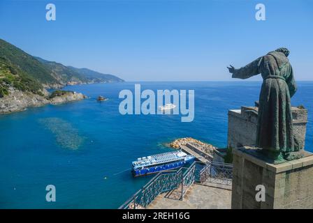 Monumento di San Francesco d'Assisi attraverso il cielo blu da sotto a Monterosso, Liguria, Italia Foto Stock
