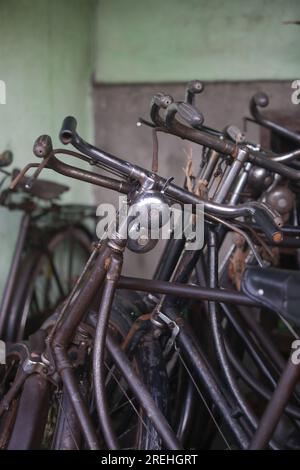Pile di biciclette arrugginite d'epoca in officina Foto Stock