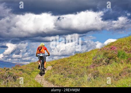 Knockan Crag West Highlands Geopark Scozia in estate un ciclista solitario sul sentiero o sentiero per falesia Foto Stock