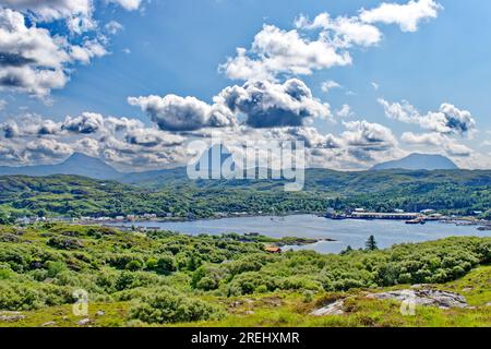 Lochinver Assynt Sutherland Scotland Canisp Suilven e cUL Mor si affacciano sulle case del villaggio e sul lago d'estate Foto Stock