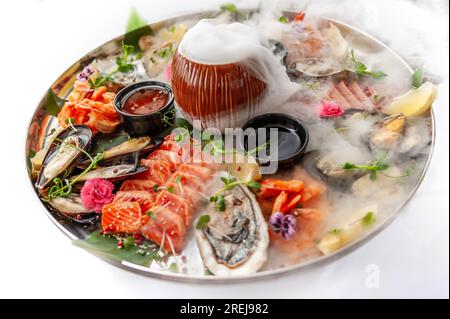 Piatto di pesce fresco con cozze, ostriche, capesante, salmone e tonno Foto Stock