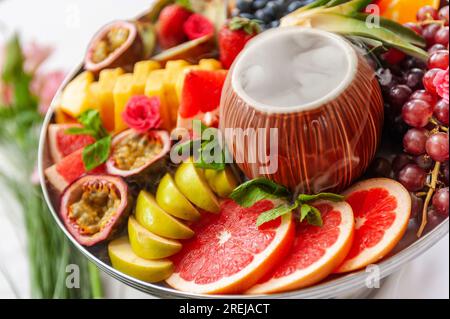 Vassoio assortito di frutta cruda e frutti di bosco sul piatto, sul tavolo bianco Foto Stock
