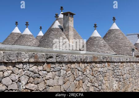 Locorotondo, Italia. 10 luglio 2023. Un gruppo di trulli, i tradizionali edifici in pietra a secco con tetto conico, visti nei pressi di Locorotondo, in Puglia, Italia, il 10 luglio 2023. Secondo un recente articolo del Guardian, la Valle d'Itria, un'ampia valle agricola nei pressi di Bari ricca di vigneti e ulivi, è uno dei luoghi più segreti d'Italia. (Foto di Elisa Gestri/Sipa USA) credito: SIPA USA/Alamy Live News Foto Stock