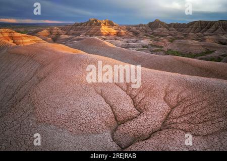 Quest'ultima luce bagna questi schemi di erosione affacciati sulle numerose vette e promontori colorate che compongono il Badlands National Park del South Dakota. Foto Stock