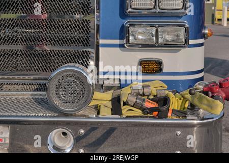 Tubi flessibili, sirena e valvole sul paraurti anteriore di un autopompa antincendio blu. Foto Stock