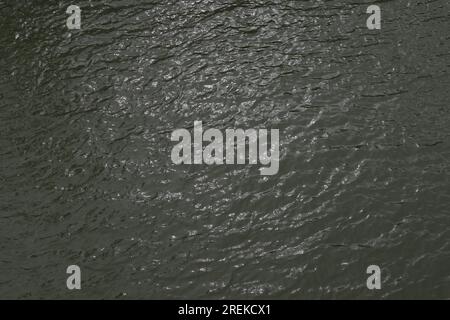 Vista ad alto angolo delle onde scintillanti della superficie dell'acqua scura del fiume Nero (il fiume Kalu) in Sri Lanka. Foto Stock