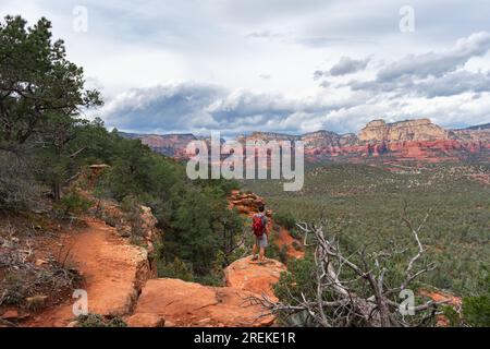 Escursionista che fa una pausa per ammirare le ampie vedute delle formazioni di roccia rossa di Sedona. Foto Stock