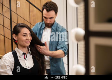 Pettini maschili barbuti capelli di giovane donna con spazzola per lo styling Foto Stock