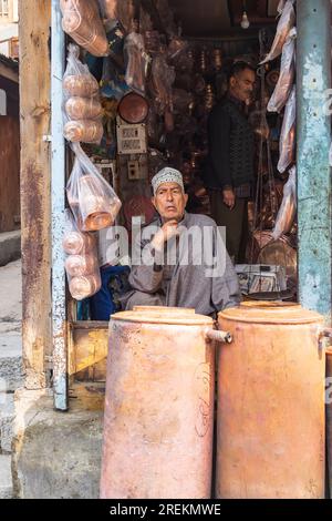 Sokalipura, Srinagar, Jammu e Kashmir, India. 25 ottobre 2022. Uomo che vende ceramiche di rame e stagno in un mercato a Srinagar. Foto Stock