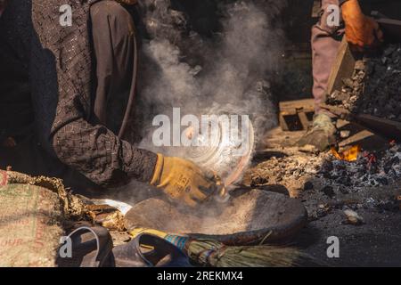 Sokalipura, Srinagar, Jammu e Kashmir, India. 25 ottobre 2022. Uomo che fa rame e stagno in un mercato a Srinagar. Foto Stock