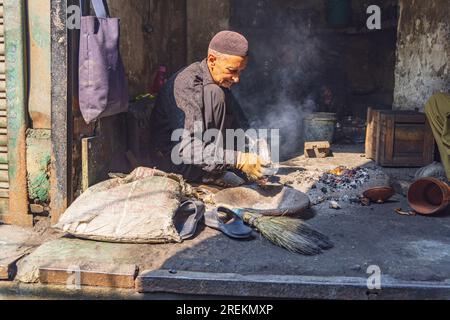 Sokalipura, Srinagar, Jammu e Kashmir, India. 25 ottobre 2022. Uomo che fa rame e stagno in un mercato a Srinagar. Foto Stock