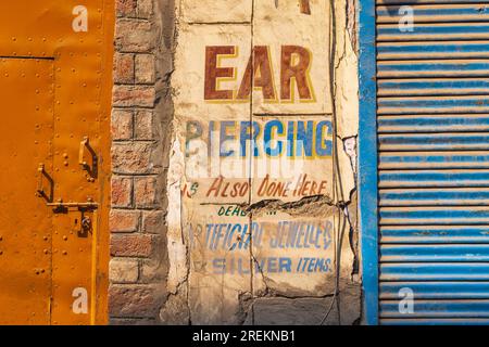 Bohri Kadal, Srinagar, Jammu e Kashmir, India. 25 ottobre 2022. Cartello pubblicitario con piercing auricolare in Srinagar. Foto Stock