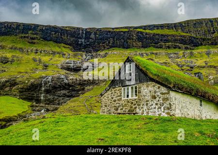 Grasstop roof House davanti a una cascata, Saksun, Streymoy, isole Faroe, Danimarca Foto Stock