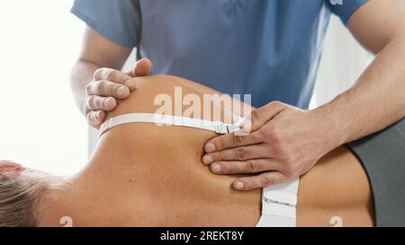 Vista frontale del terapista osteopatico che controlla la schiena della paziente 2. Risoluzione e foto bellissime di alta qualità Foto Stock