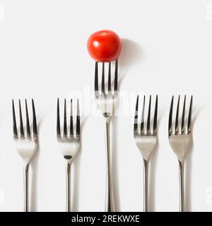 Forchetta di pomodoro rosso ciliegia su sfondo bianco. Bella foto Foto Stock