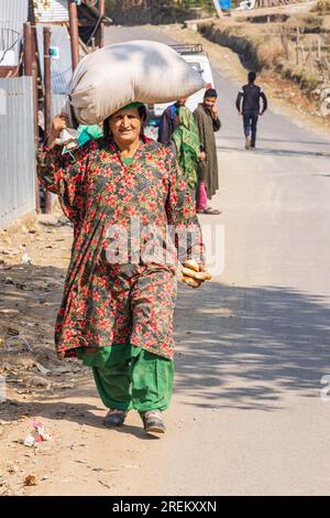 Berna Bugh, Kangan, Jammu e Kashmir, India. 27 ottobre 2022. Una donna che porta una borsa sulla testa in un villaggio di Jammu e Kashmir. Foto Stock